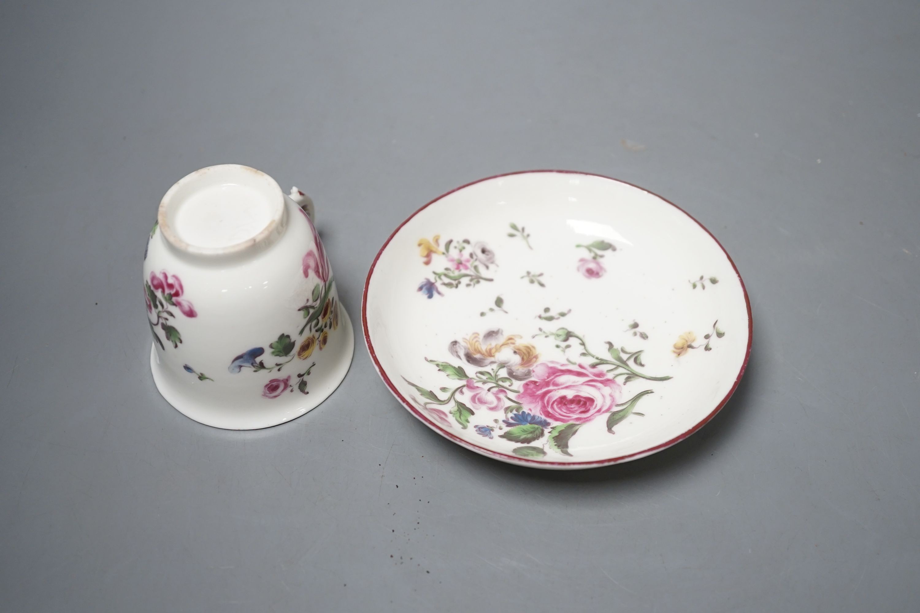 A Mennecy coffee cup and saucer painted with bold flowers, incised 'DV' mark c. 1755